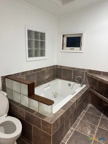 a bath tub sitting next to a white toilet