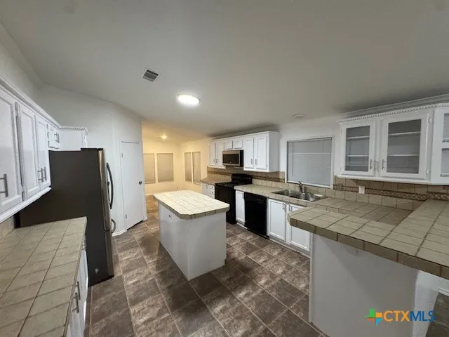 a open kitchen with a sink dishwasher stove top oven and refrigerator