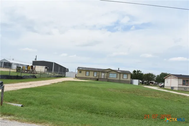 a view of a house with a big yard and large trees