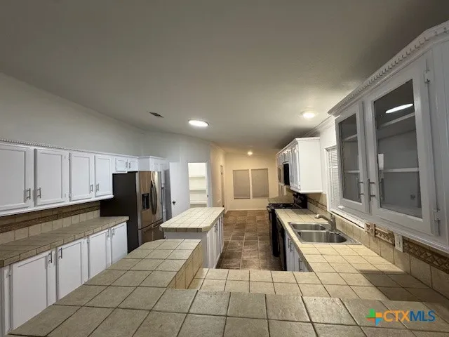 a large kitchen with a large window and stainless steel appliances