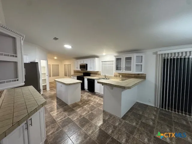 a large kitchen with a large counter top appliances and cabinets