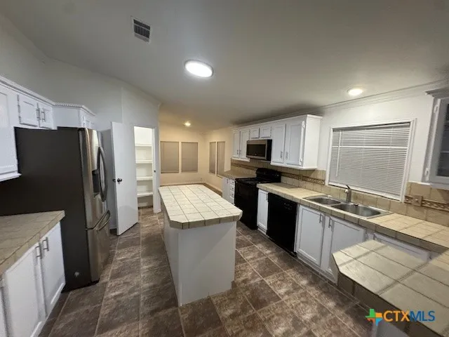 a large kitchen with stainless steel appliances kitchen island granite countertop a refrigerator stove microwave and sink