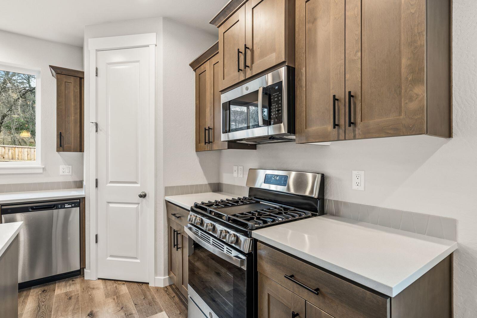 669 Old Waverly Way, Unit 20 Eagle Point, OR 97524 - Photo 11 of 32 a kitchen with stainless steel appliances a stove microwave and cabinets