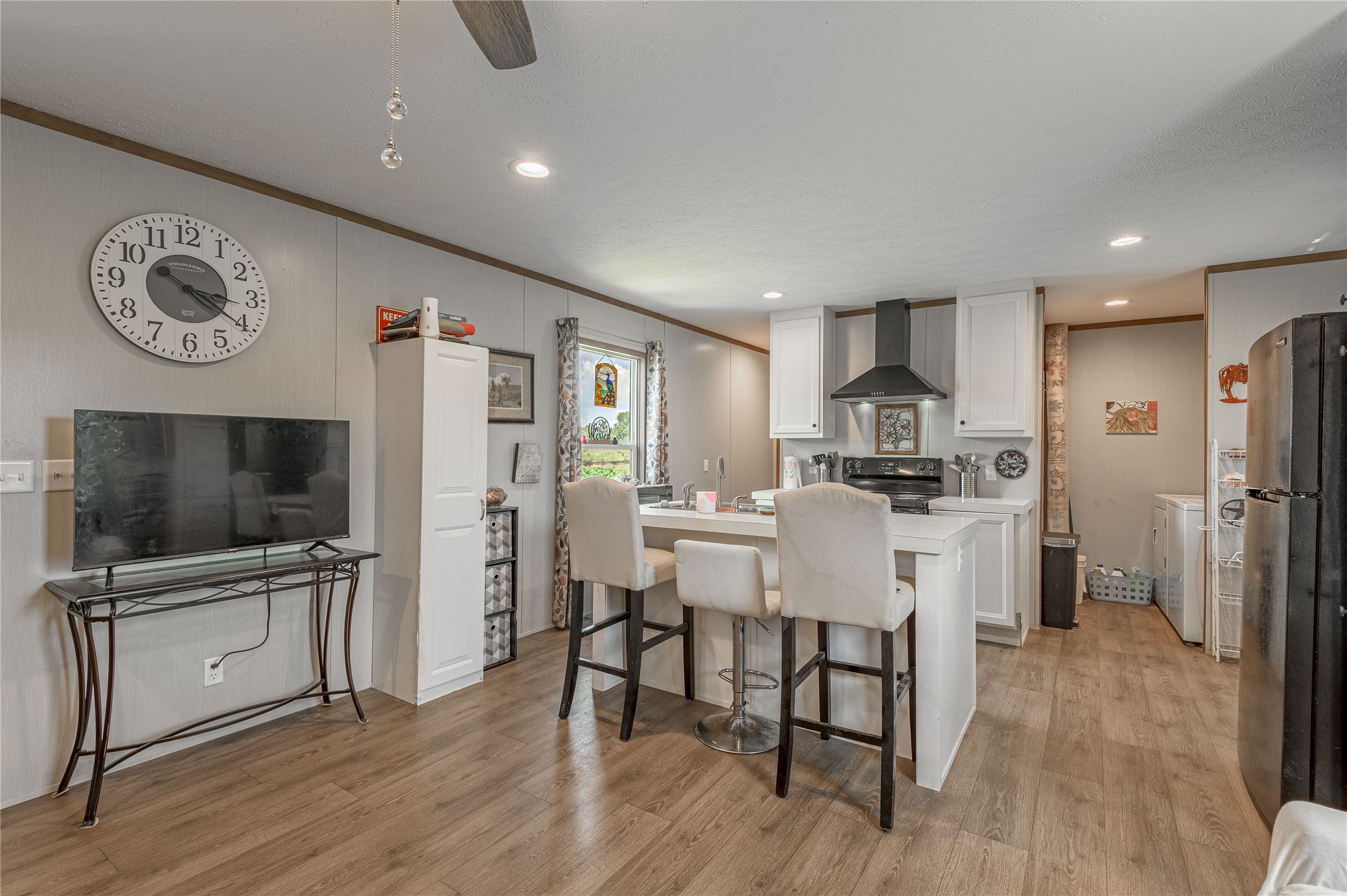 998 East 1st Street Groveton, TX 75845 - Photo 6 of 25 a living room with stainless steel appliances furniture a flat screen tv and a kitchen view