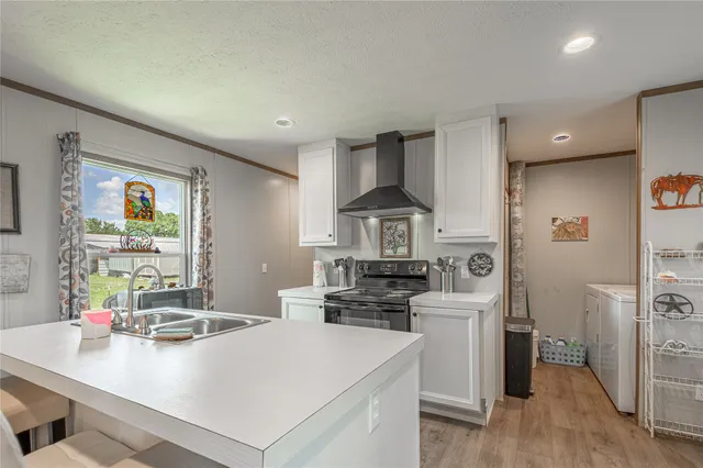 a kitchen that has a sink a stove and a wooden floor