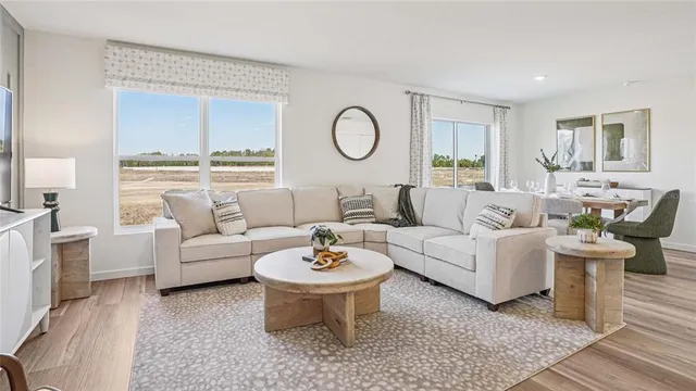 a living room with furniture a table and a large window