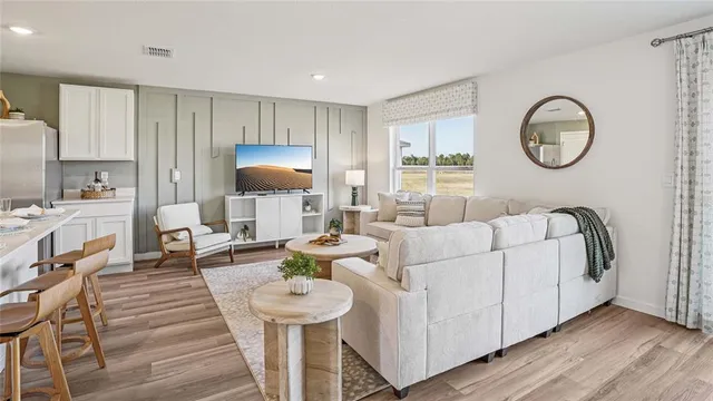 a living room with furniture a clock and a window