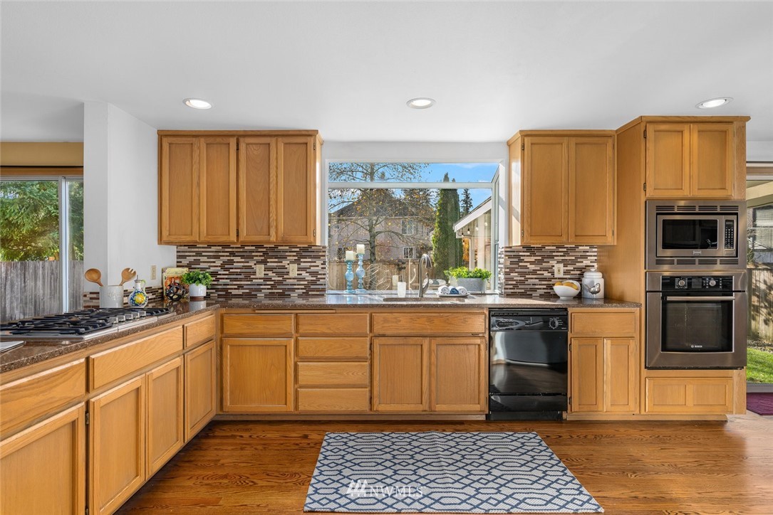 4603 Northeast 19th Street Renton, WA 98059 - Photo 11 of 30 a kitchen with stainless steel appliances granite countertop a sink stove and refrigerator