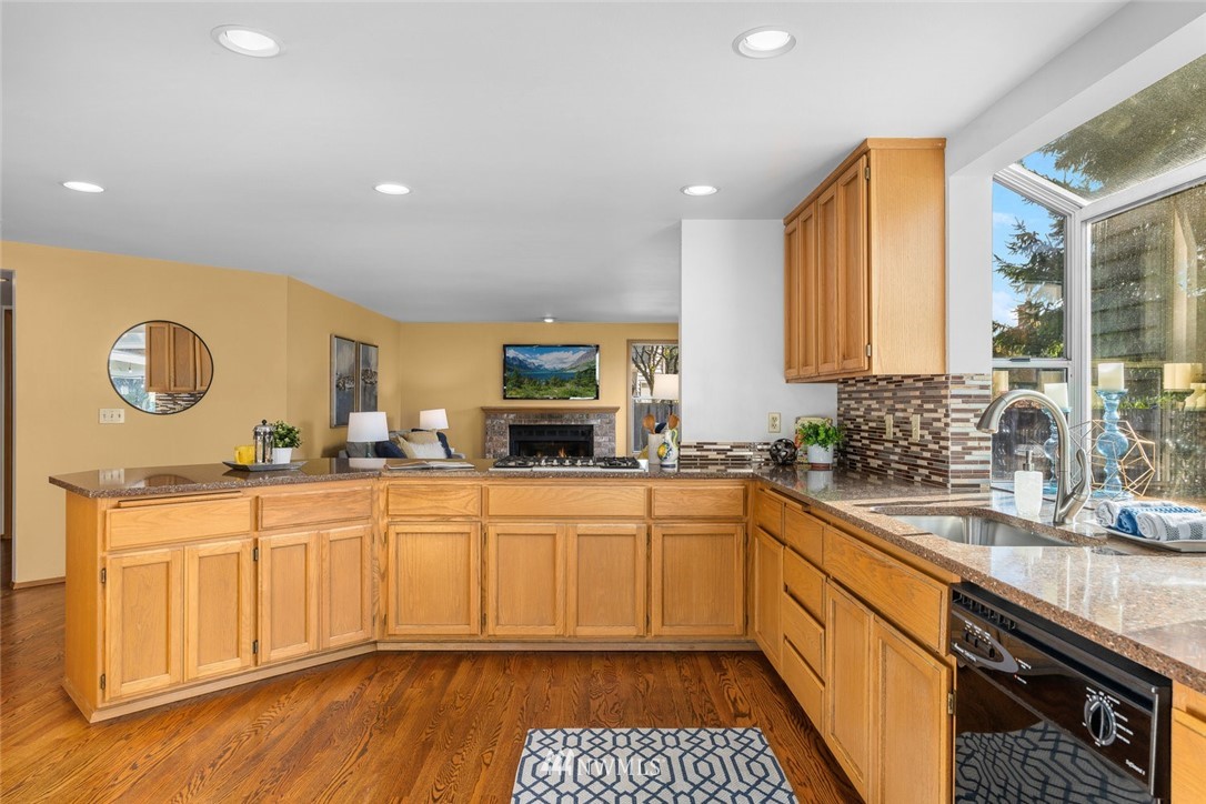 4603 Northeast 19th Street Renton, WA 98059 - Photo 12 of 30 a kitchen with stainless steel appliances granite countertop a sink and cabinets