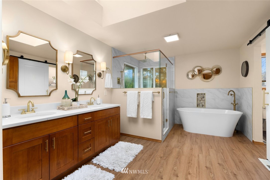4603 Northeast 19th Street Renton, WA 98059 - Photo 20 of 30 a spacious bathroom with a double vanity sink a mirror and a bathtub
