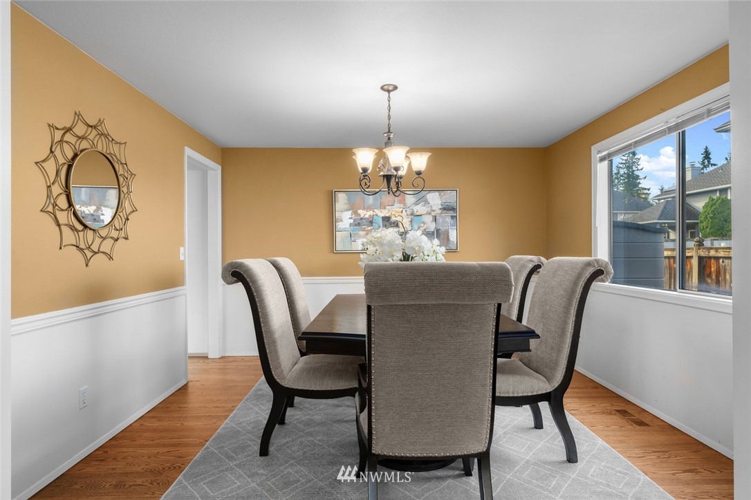 4603 Northeast 19th Street Renton, WA 98059 - Photo 9 of 30 a dining room with furniture a chandelier and wooden floor