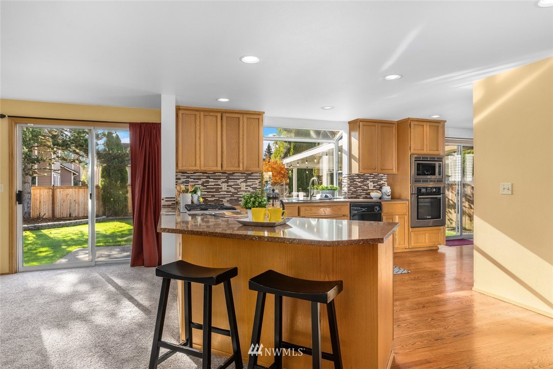 4603 Northeast 19th Street Renton, WA 98059 - Photo 10 of 30 a dining hall with stainless steel appliances a dining table and chairs with the wooden floor
