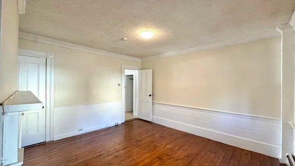 a view of empty room with wooden floor