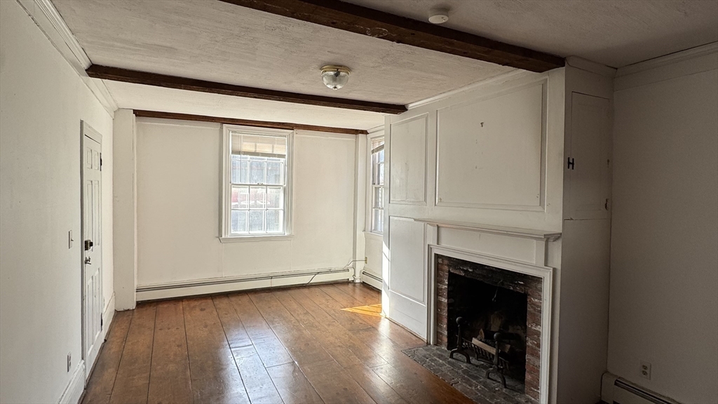 18 State Street, Unit 1 Marblehead, MA 01945 - Photo 2 of 16 a view of an empty room with wooden floor and a window