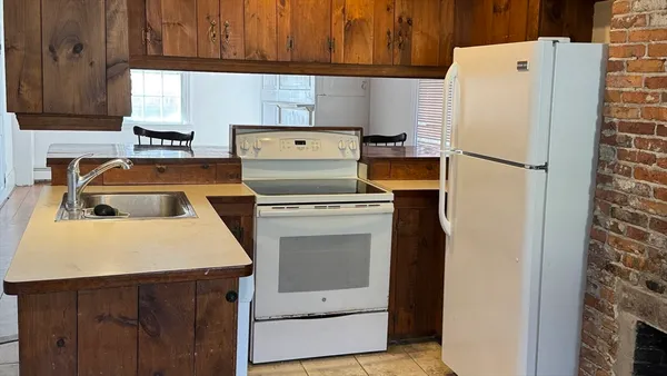 a white refrigerator freezer and a stove sitting inside of a kitchen