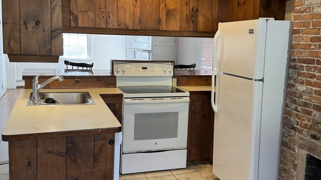18 State Street, Unit 1 Marblehead, MA 01945 - Photo 6 of 16 a white refrigerator freezer and a stove sitting inside of a kitchen