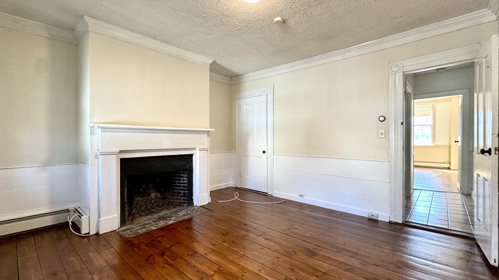 18 State Street, Unit 1 Marblehead, MA 01945 - Photo 9 of 16 a view of an empty room with wooden floor and a window