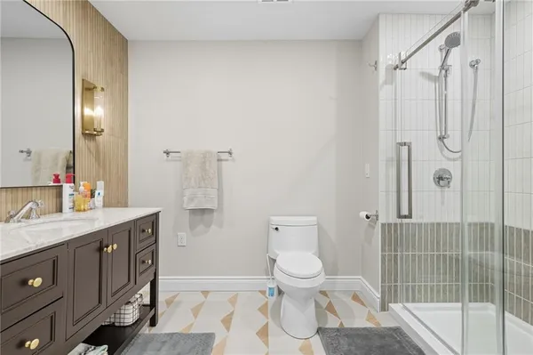 a bathroom with a granite countertop sink toilet and shower