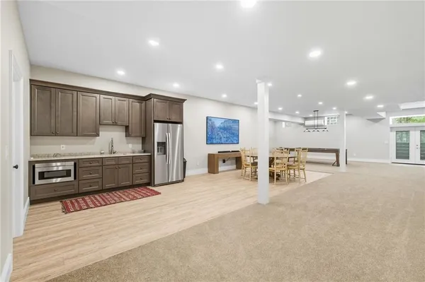 a large kitchen with stainless steel appliances lots of counter space and a chair
