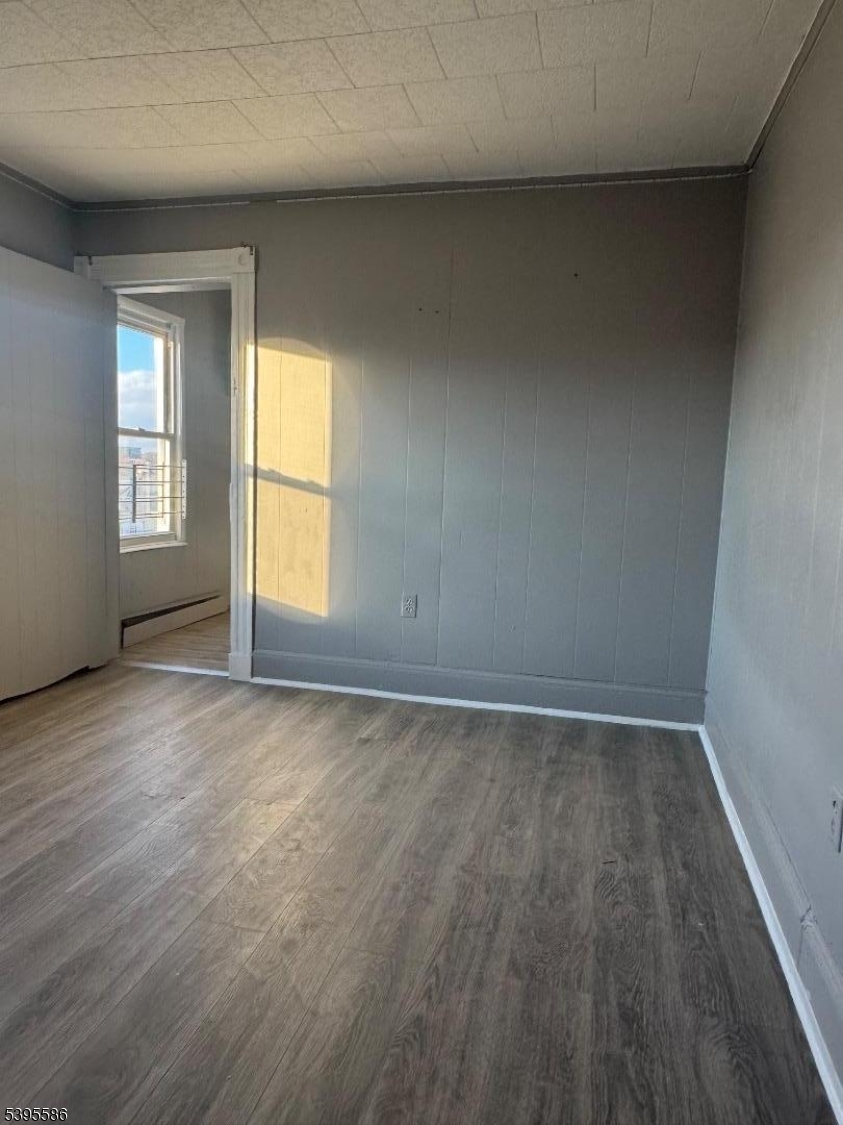 467 21st Avenue Paterson, NJ 07513 - Photo 6 of 7 an empty room with wooden floor and windows