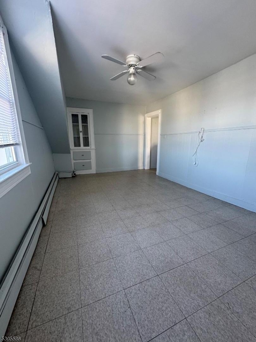 467 21st Avenue Paterson, NJ 07513 - Photo 7 of 7 en empty room with windows and ceiling fan