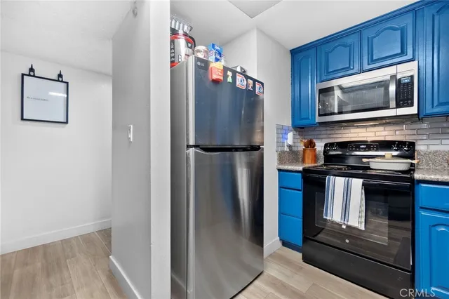 a kitchen with stainless steel appliances granite countertop a refrigerator stove and microwave