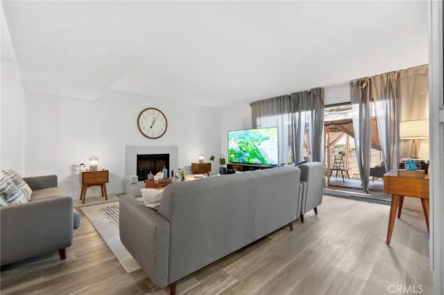 a living room with furniture a fireplace and a large window