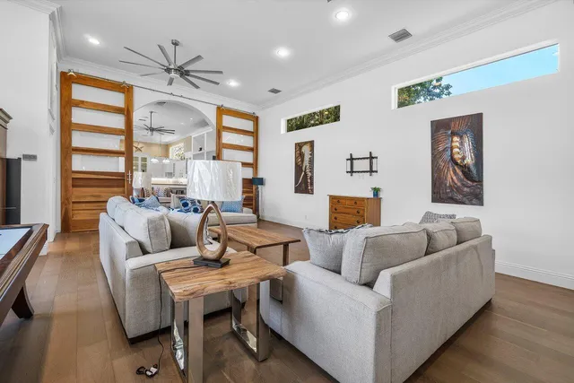 a living room with furniture and a refrigerator