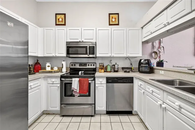 a kitchen with white cabinets a sink and white appliances