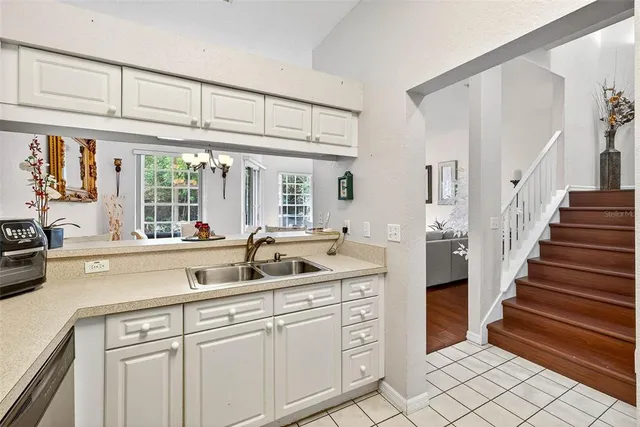 a very nice looking kitchen with granite countertop a sink and cabinets