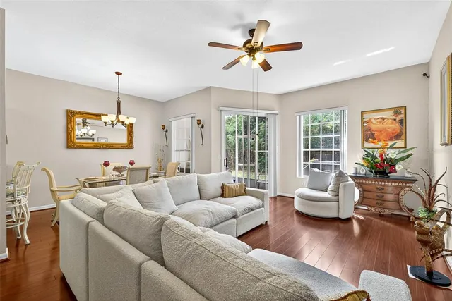 a living room with furniture ceiling fan and a window