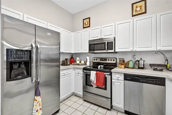 a kitchen with stainless steel appliances granite countertop a refrigerator a stove and a sink with wooden floor