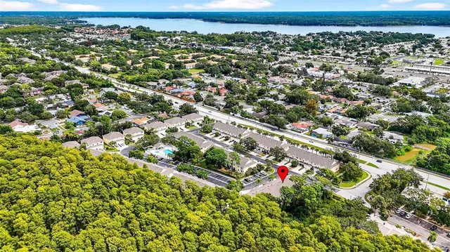 an aerial view of residential houses with outdoor space and trees