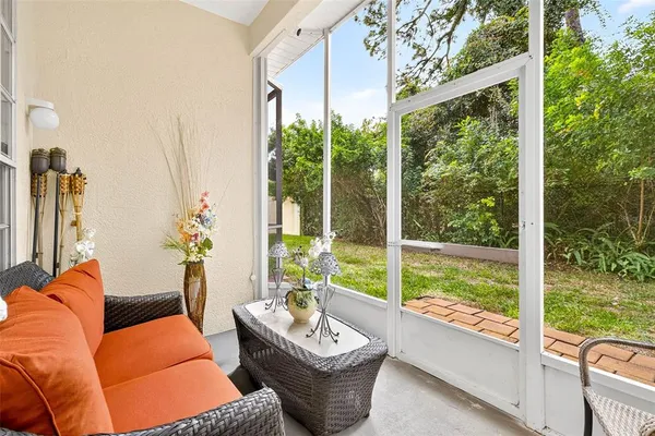 a living room with patio furniture and a large window