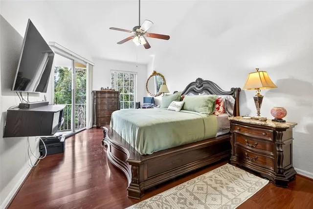 a bedroom with a bed a flat screen tv and a large window with the outer view