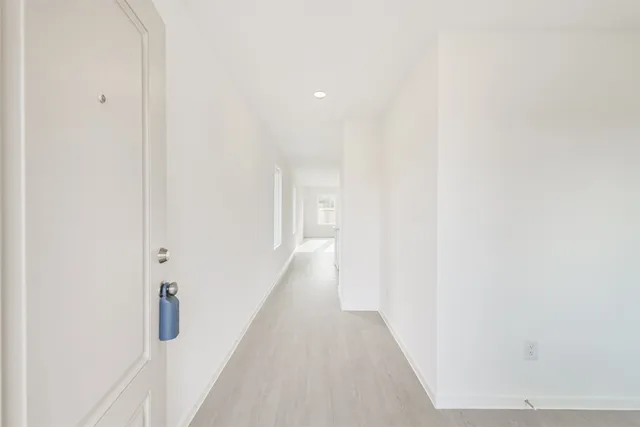 a view of a hallway with wooden floor