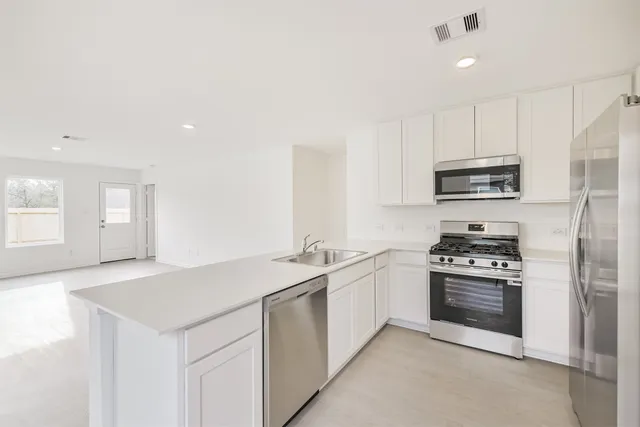 a view of a kitchen with kitchen sink and cabinets