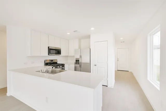 a kitchen with stainless steel appliances granite countertop a sink and a stove