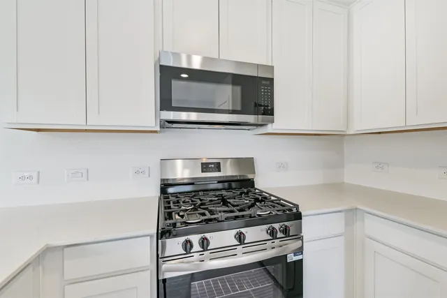 a view of kitchen with kitchen island white cabinets and wooden floor