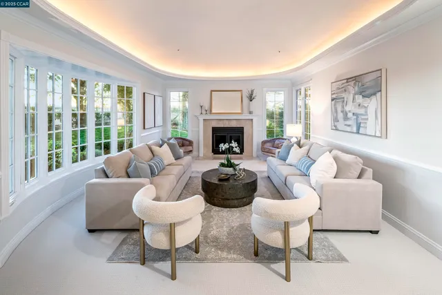 a living room with furniture a fireplace and a large window