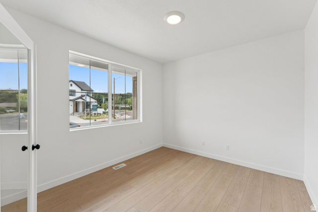 1004 West Paramount Cove South, Unit 315 Ogden, UT 84405 - Photo 16 of 42 Main floor office featuring a large window, light wood-finish flooring, white walls, and a ceiling-mounted light fixture