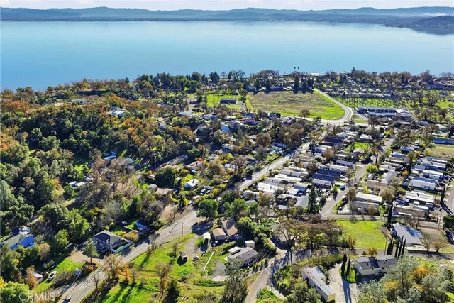 an aerial view of residential houses with outdoor space and trees