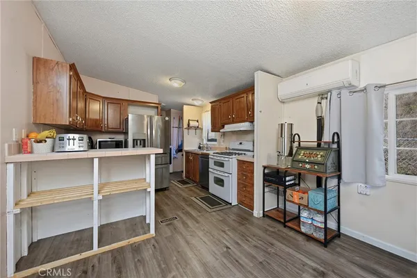 a kitchen with a stove a refrigerator and cabinets