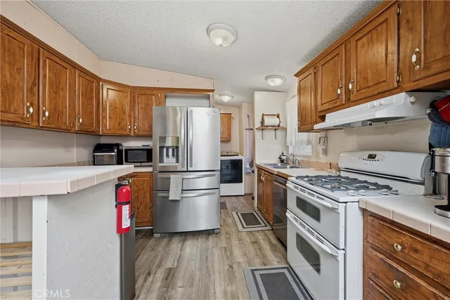 a kitchen with granite countertop stainless steel appliances and wooden cabinets