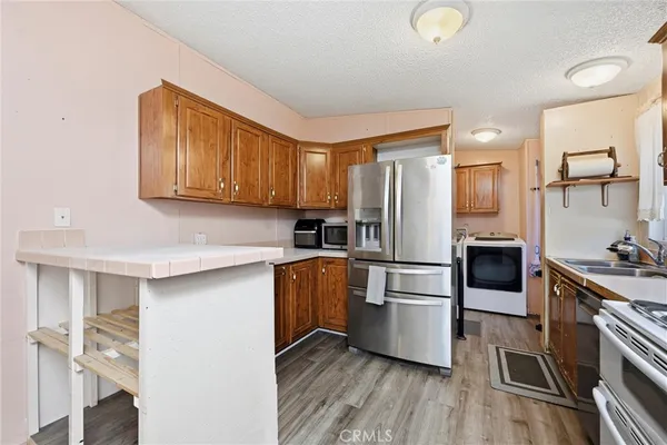 a kitchen with stainless steel appliances a stove top oven a sink and a refrigerator