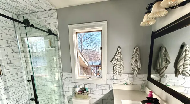 a view of balcony with two chairs and wooden fence
