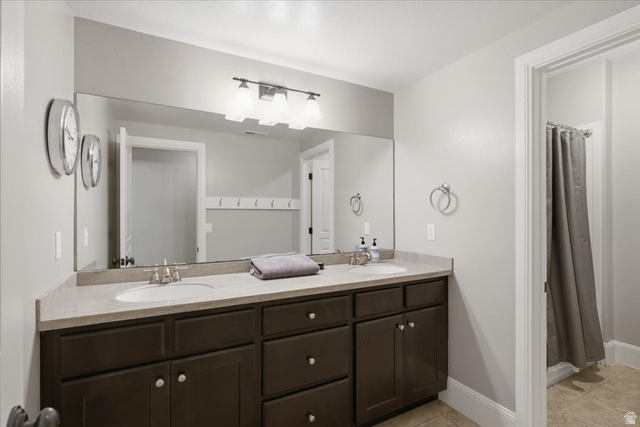 1257 Rigby Road Kaysville, UT 84037 - Photo 32 of 55 Bathroom featuring a dual vanity with dark wood-finish cabinetry, light-toned countertop, and undermount sinks