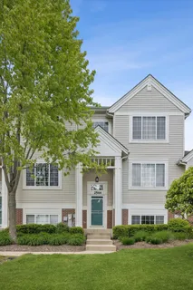 a front view of a house with a yard and trees