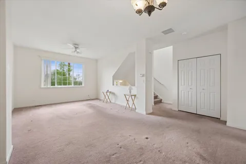 an empty room with windows and ceiling fan view