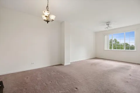 an empty room with windows and chandelier